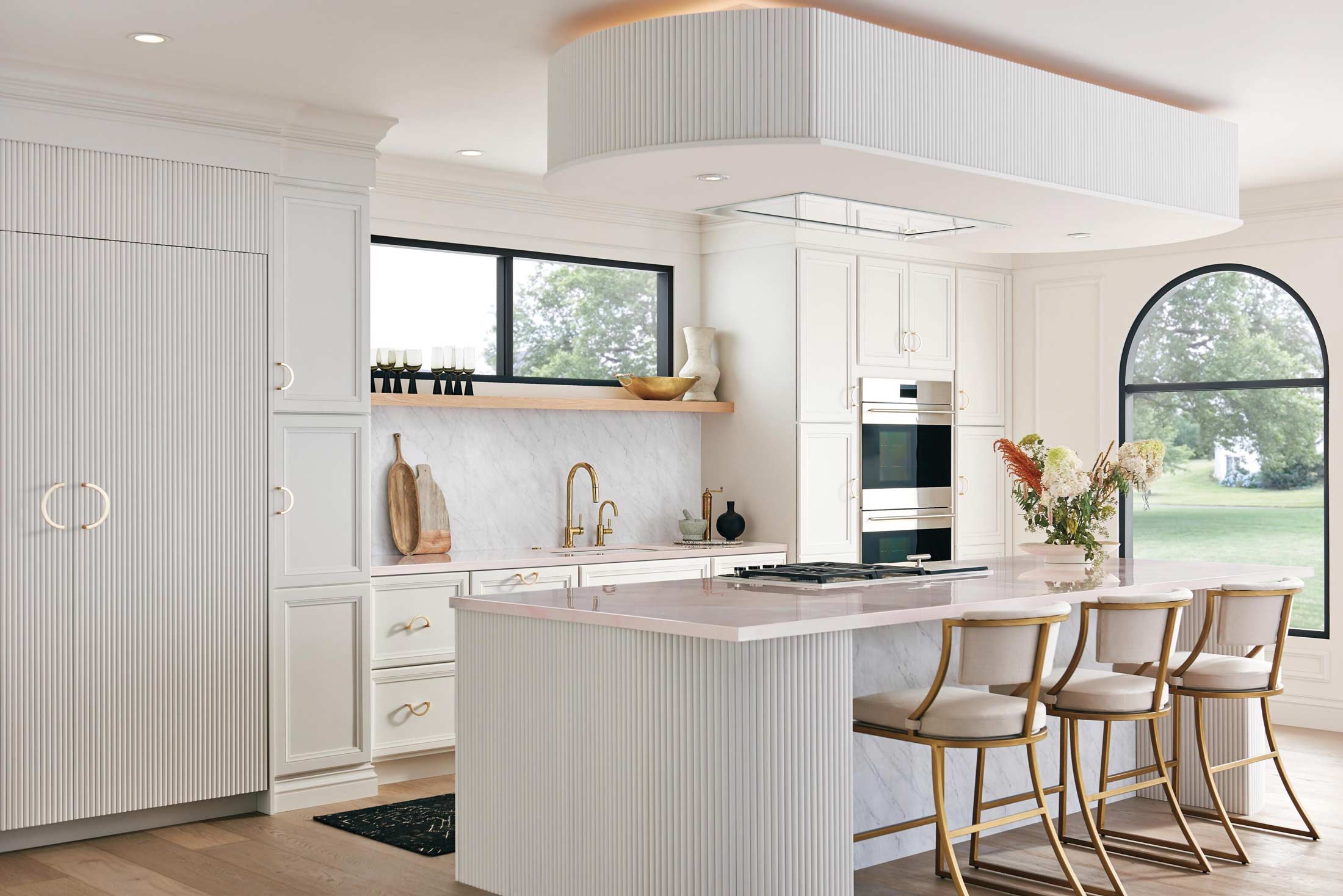 A large modern kitchen painting white with gold accents